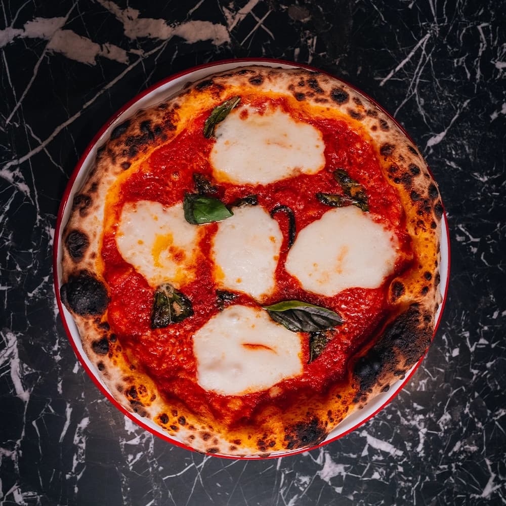 Freshly baked margherita pizza with melted mozzarella, basil, and tomato sauce